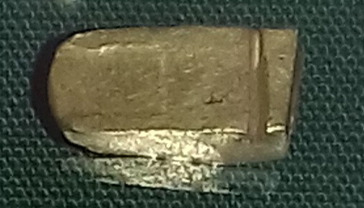A rounded gold ingot terminal cut from an ingot of rectangular cross-section.